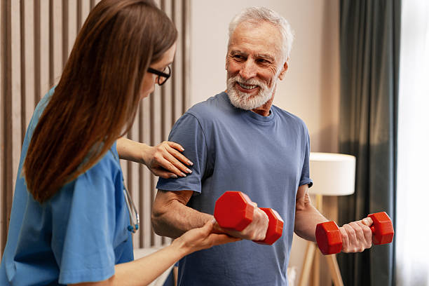 istock Nurse assisting senior man lifting weights during home visit physiotherapy session 2226789688