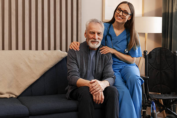 istock Smiling female nurse supporting elderly man sitting on sofa at home 2226789689