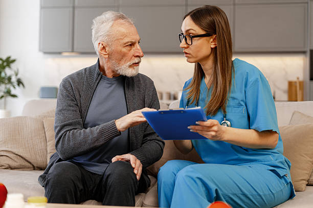 istock Nurse visiting elderly man at home discussing medical chart 2226789712