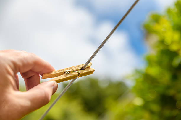 Putting a wooden clothes peg on the line