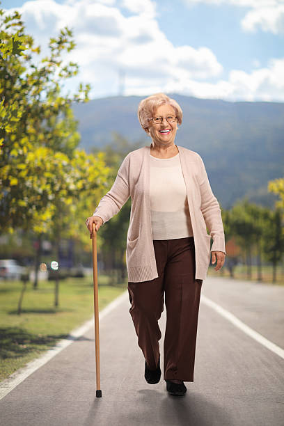 istock Smiling elderly woman walking with a cane 2226791134