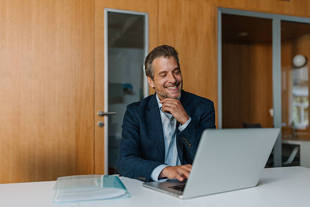 istock Smiling man working on laptop in an office space 2226792509