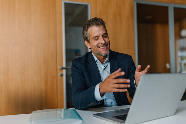 Smiling businessman in stylish office during video call