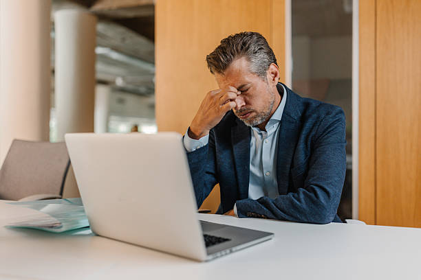 istock Thoughtful man contemplating at a desk with laptop 2226792936