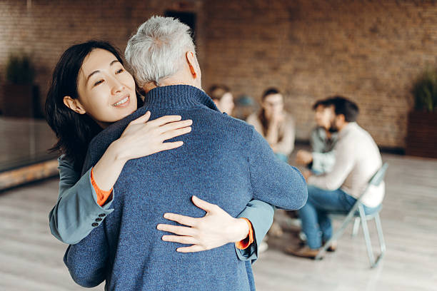 istock Asian businesswoman supporting senior man at group therapy session 2226795543