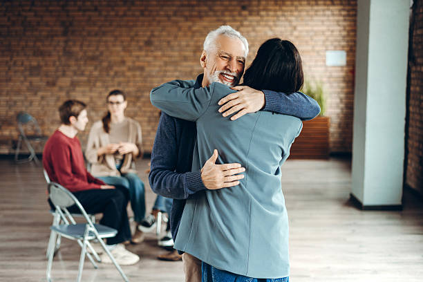 istock Senior man and businesswoman hugging during group therapy session 2226795557