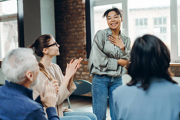 istock Smiling African American woman receiving applause from support group members clapping 2226795566