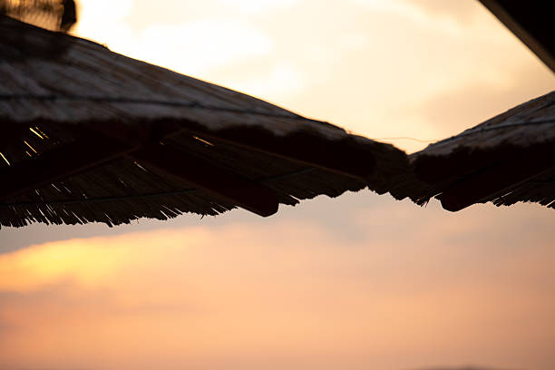 Sky with light clouds over the sea. In the foreground a bamboo sunshade. Sunset on a summer evening. Fazana, Croatia - circa 2025