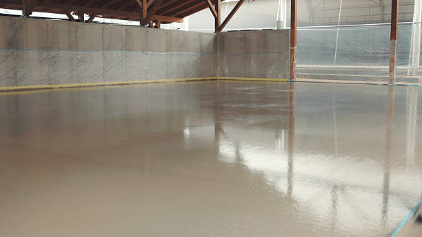istock Workers finishing wet concrete floor inside building under construction 2226796699