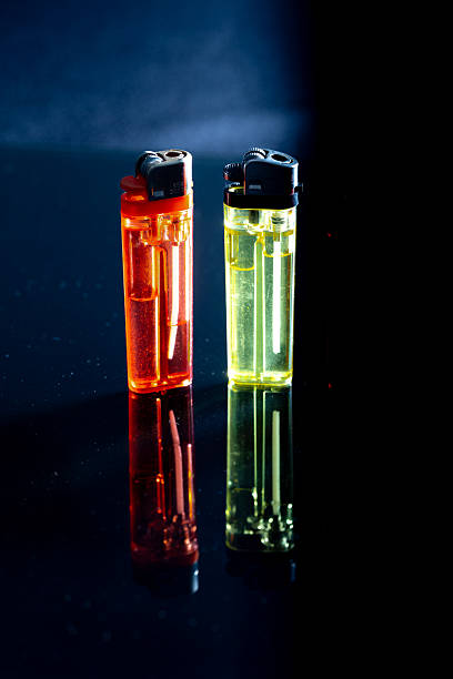 istock Two colorful lighters reflecting on dark surface with backlight 2226797507