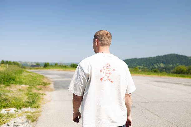 istock Man Walking Along Road in Countryside on Sunny Day 2226810061