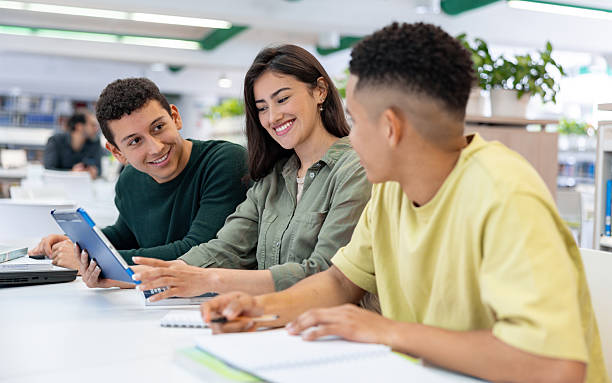 istock Happy group of students studying at the library using a digital tablet 2226813037