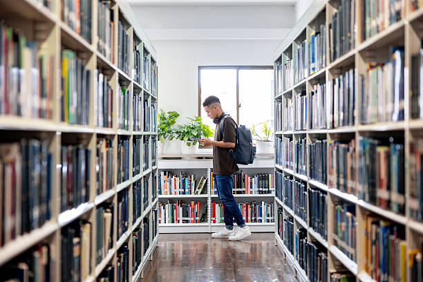 Latin American college student walking around the aisles of a library - education concepts