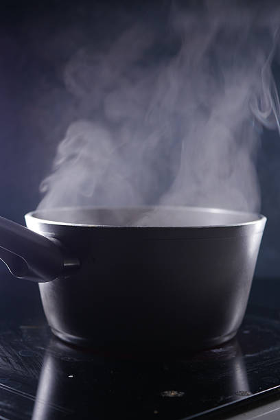 istock Cooking pot emits steam on a dark kitchen surface at night 2226816066