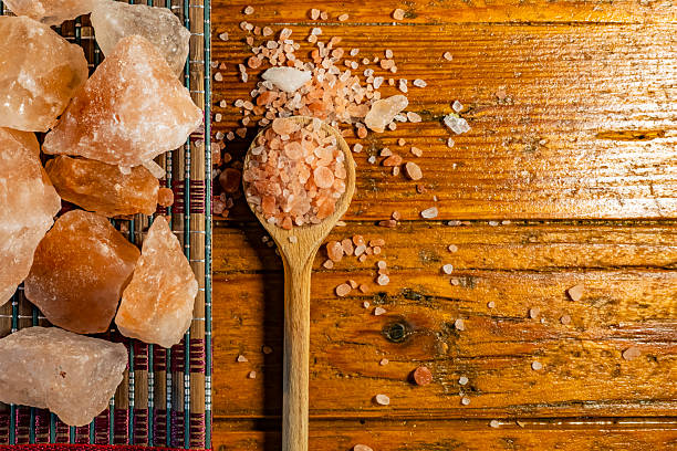 Himalayan salt - large and medium size pieces on a table with wooden spun