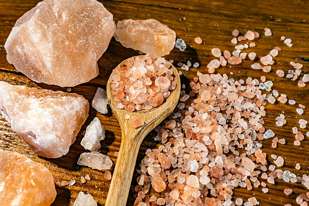 Himalayan salt - large and medium size pieces on a table with wooden spun