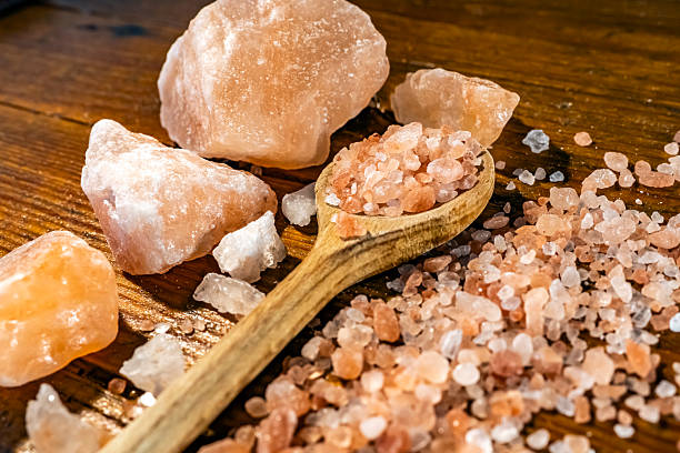 istock Himalayan salt - large and medium size pieces on a table with wooden spun 2226819727