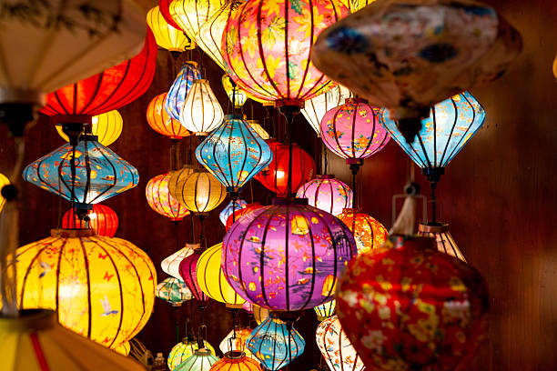 istock Vibrant, intricately patterned lanterns in assorted shapes and colors hang gracefully along a timeworn Vietnam market, showcasing exquisite traditional artistry. 2226823399