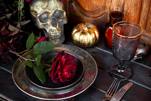 istock Served table with autumn decor, red roses, scull and pumpkin. Halloween dinner table setting 2226824086
