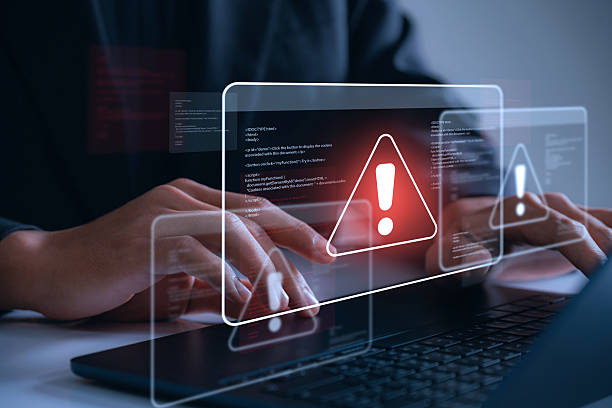 istock Cybersecurity alert concept with hacker phishing laptop showing warning sign showing cyberattack, malware and code error on screen to indicate a data breach, internet scam, or system threat. 2226827176