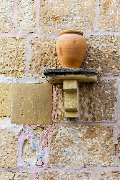 istock Rustic Clay Jug on a Stone Shelf Against a Textured Wall 2226827226