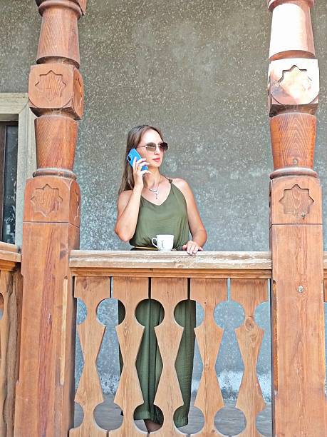 young woman with cellphone standing on the balcony. High quality photo