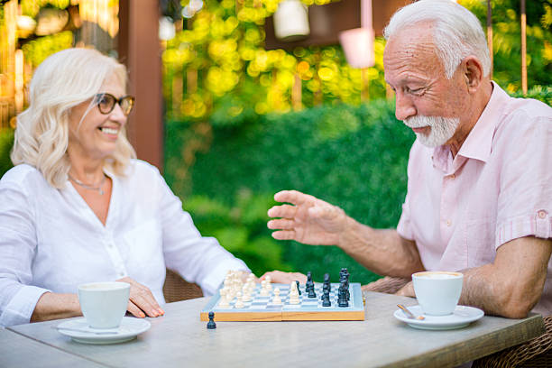 istock Senior couple playing chess and drinking coffee outdoors 2226829267