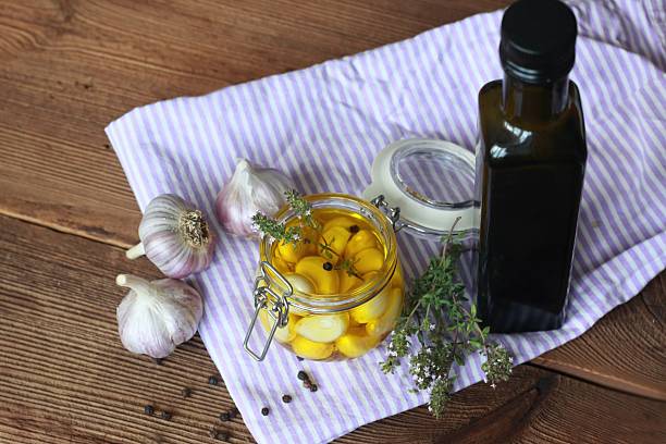 istock Garlic cloves pickled in olive oil and thyme. 2226829331