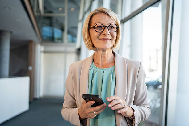 istock Smiling senior businesswoman using smartphone in modern office 2226829341