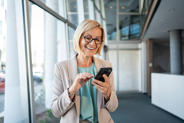 istock Smiling senior businesswoman using smartphone in modern office 2226829343