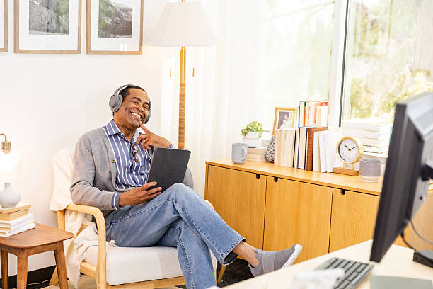 istock Happy mature man using tablet and headphones at home 2226833756