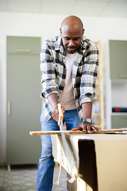 istock Carpenter sawing wood plank in his workshop 2226834129