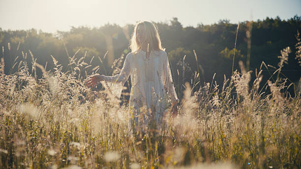 istock Woman Walking through Tall Grass in a Field 2226836169