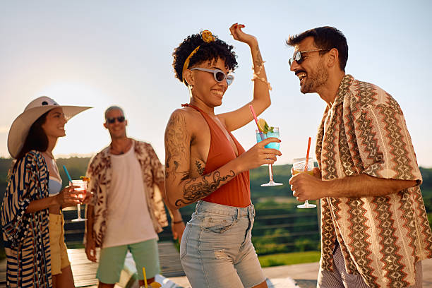 istock Happy multiracial couple having fun in summer while drinking cocktails and dancing on a patio. 2226836412