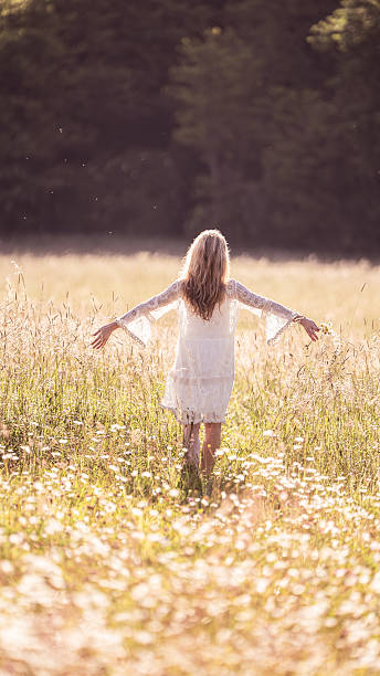 istock Girl Standing with Arms Outstretched in a Field 2226838202