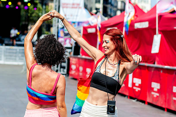 istock Two women holding hands and dancing at pride parade 2226839135