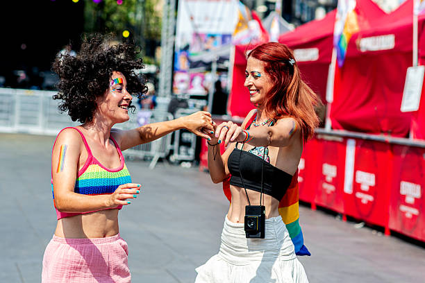 istock Two women holding hands and dancing at pride parade 2226839141