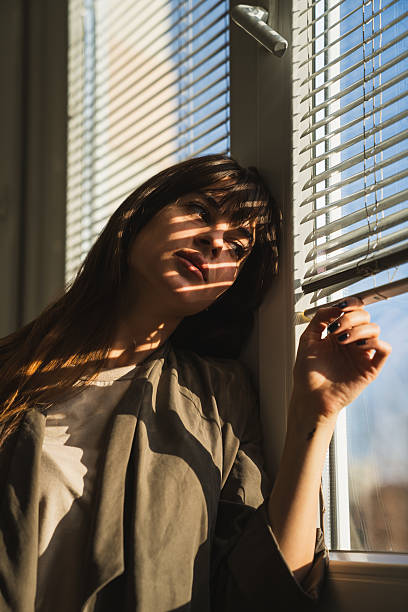 istock Beautiful woman looking out window sadly 2226842186