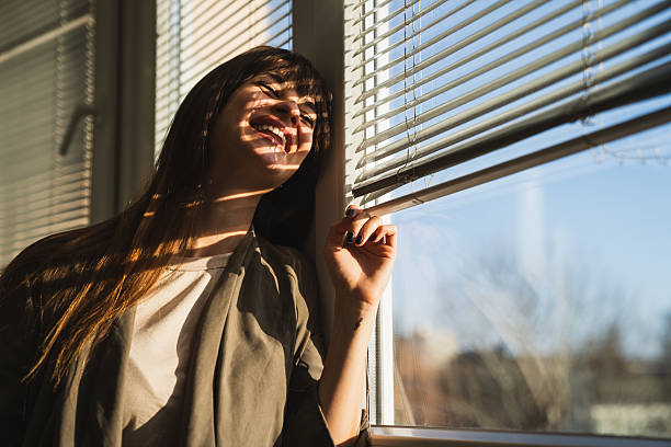istock Beautiful woman smiling at window 2226842261