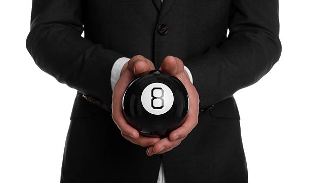 istock Man holding magic eight ball on white background, closeup 2226850515
