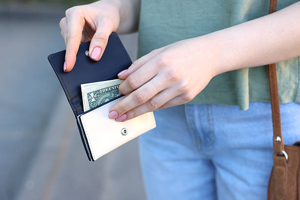 istock Woman holding purse with banknotes outdoors, closeup 2226850672