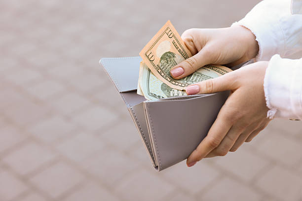 istock Woman holding purse with banknotes outdoors, closeup 2226850681