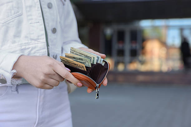 istock Woman holding purse with banknotes outdoors, closeup. Space for text 2226850709