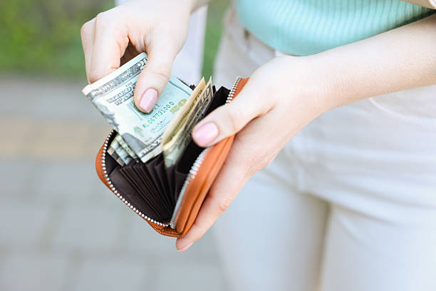 istock Woman holding purse with banknotes outdoors, closeup 2226850736