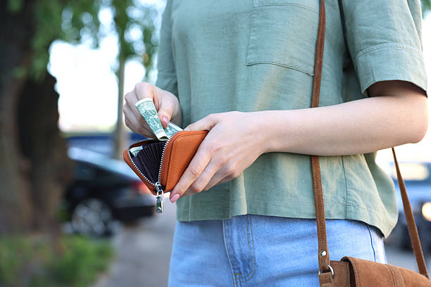 istock Woman holding purse with banknotes outdoors, closeup 2226850743