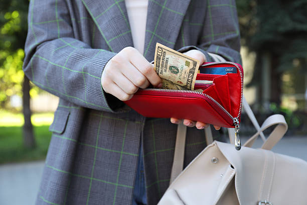 istock Woman holding purse with banknotes outdoors, closeup 2226850763