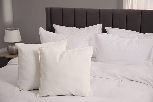 istock Many soft white pillows and duvet on bed indoors 2226851847