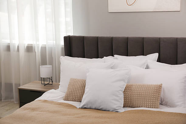 istock Many soft white pillows and blanket on bed indoors 2226851957