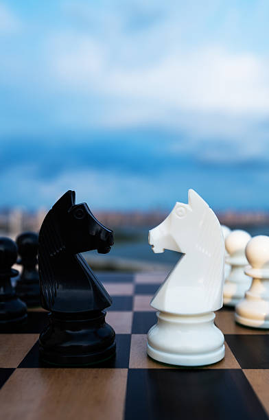 istock Two chess knights battle on city background 2226852490