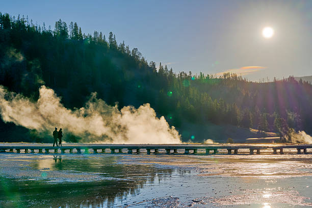 Yellowstone National Park in the state of Wyoming on October 02, 2024:  Couple out for early morning sight seeing along the boardwalk by the Grand Prismatic Spring in Yellowstone National Park